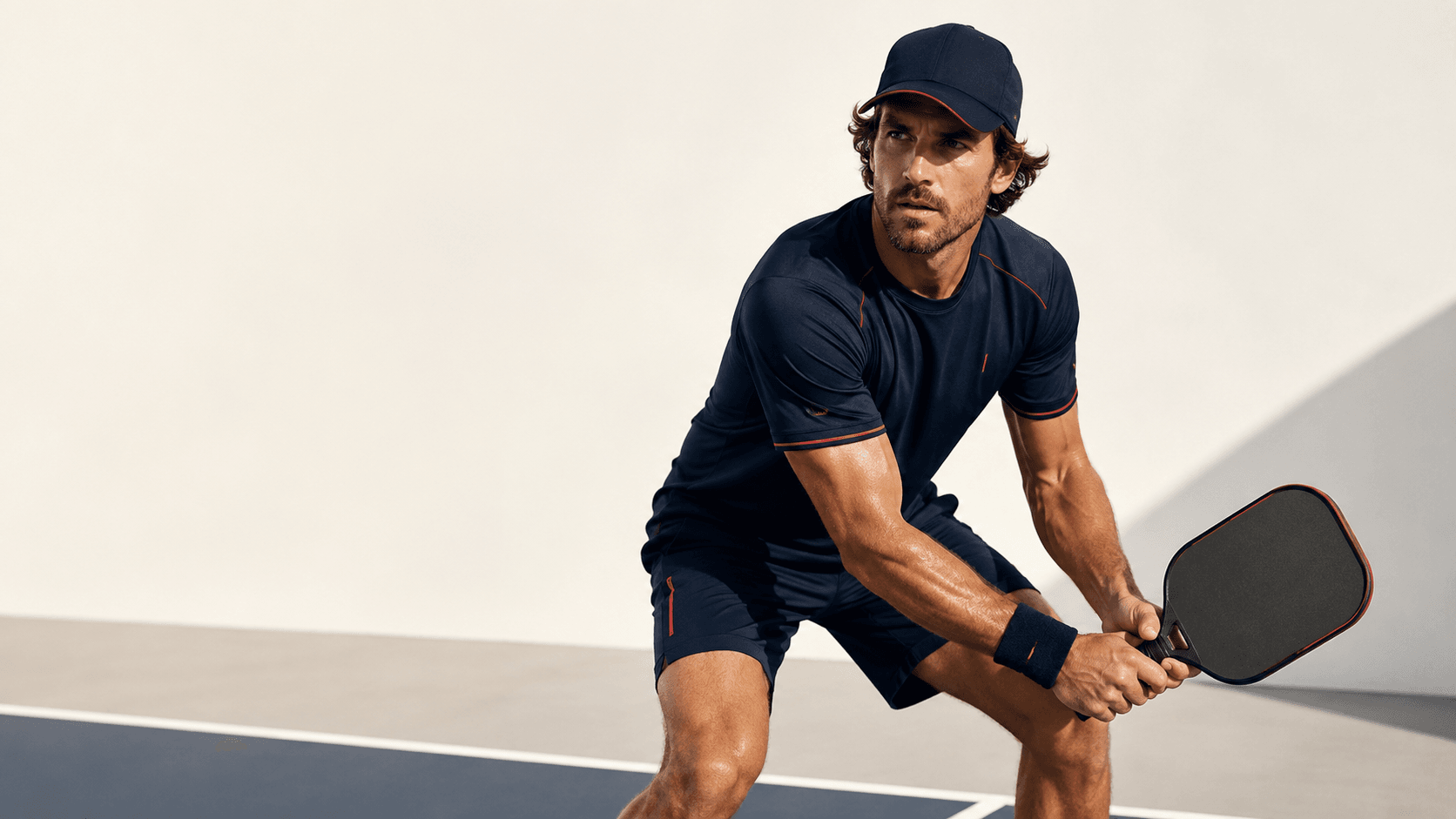 Intense competitive pickleball player in aggressive stance on professional court with dramatic stadium lighting and deep shadows